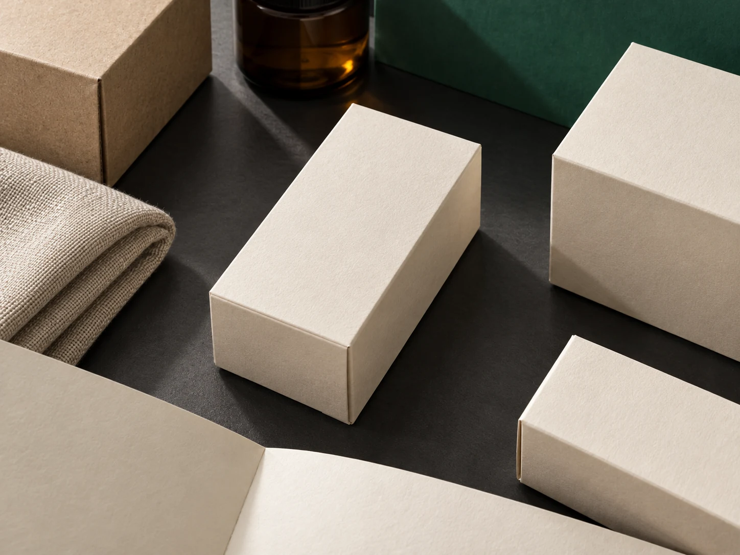 Unbranded cream cartons and natural materials arranged on a charcoal and green surface